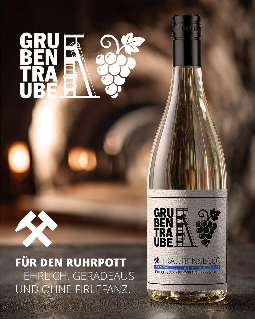 Grubentraube Traubensecco 0,0 Flasche im warm beleuchteten Stollen/Weinkeller, Etikett mit Zechenturm und Traube, alkoholfreier prickelnder Secco „für den Ruhrpott – ehrlich, geradeaus und ohne Firlefanz“.